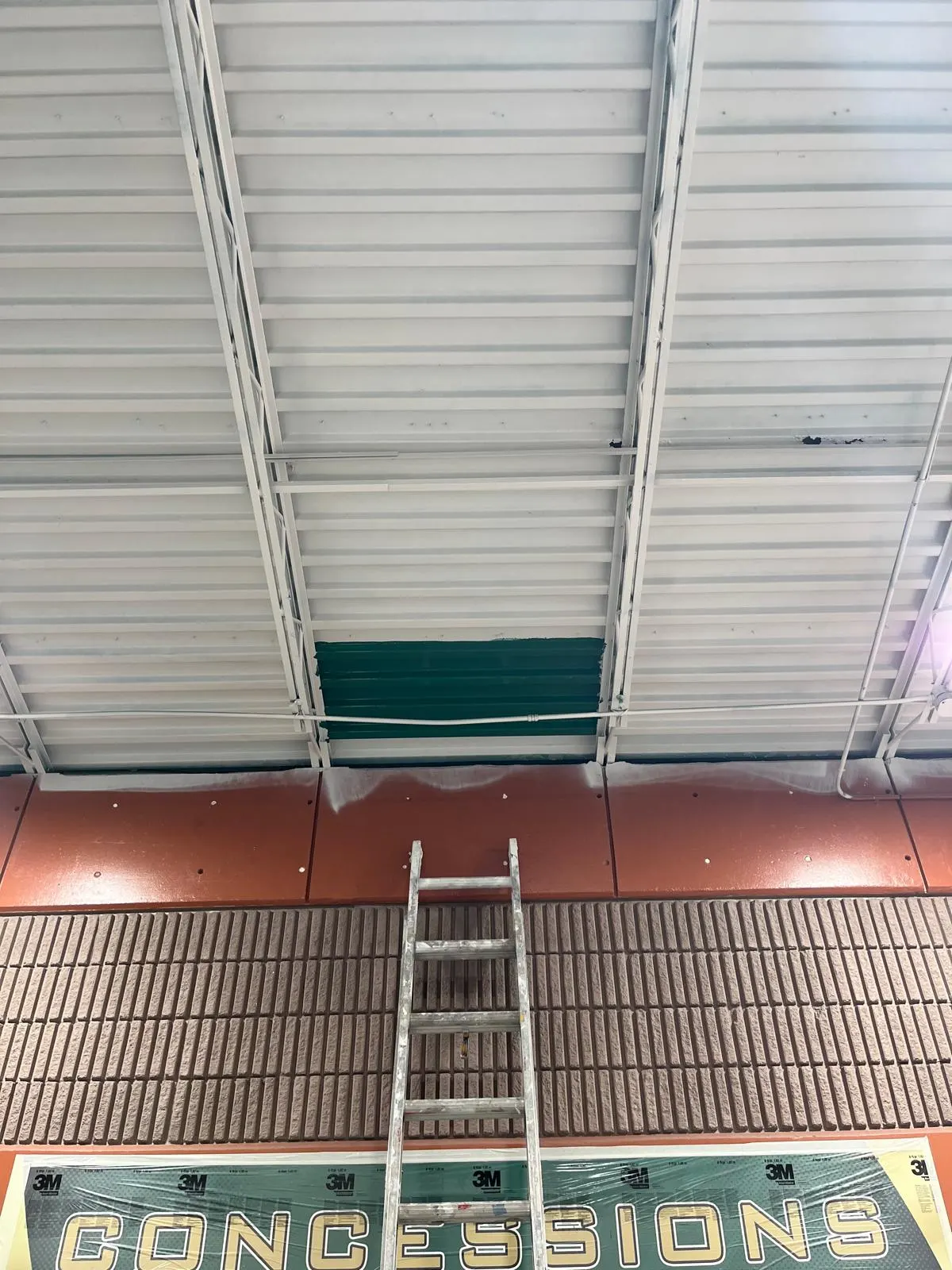 Painted ceiling and structural steel above a school concession stand
