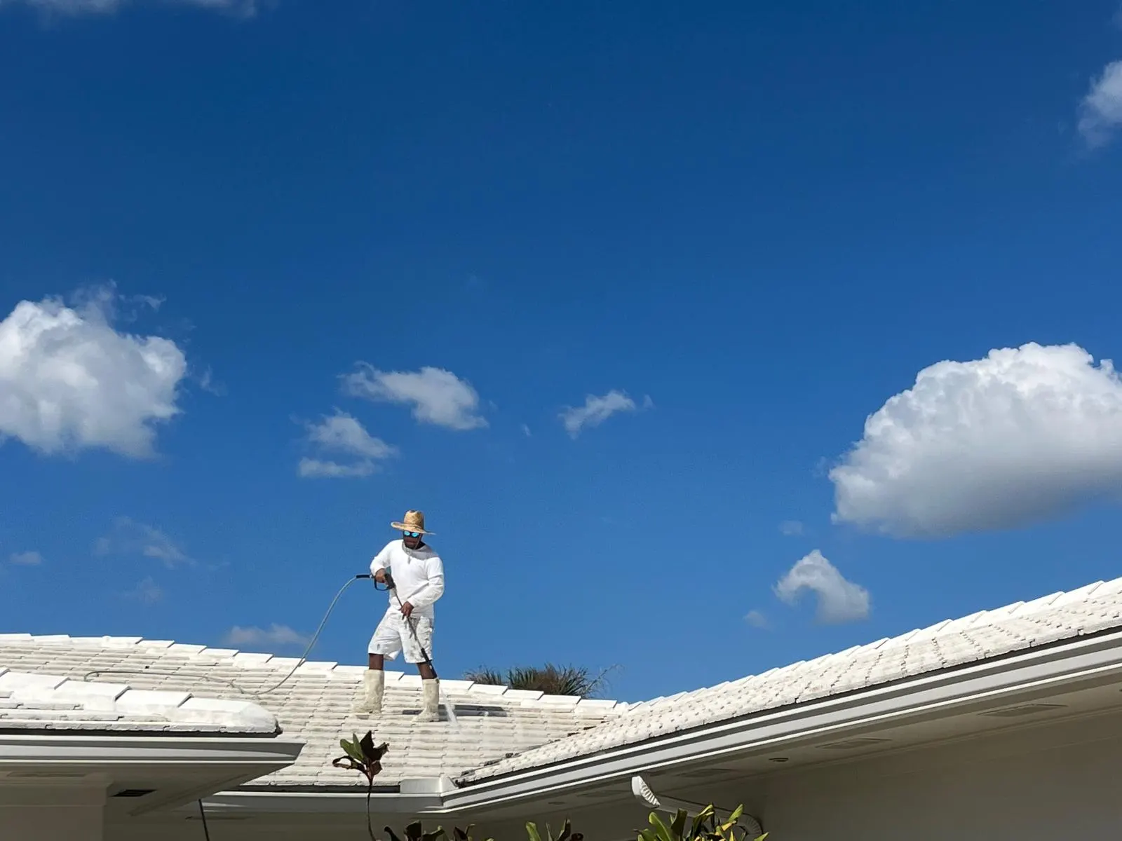 Jr Pro Painting crew member working on a roof during an exterior painting project