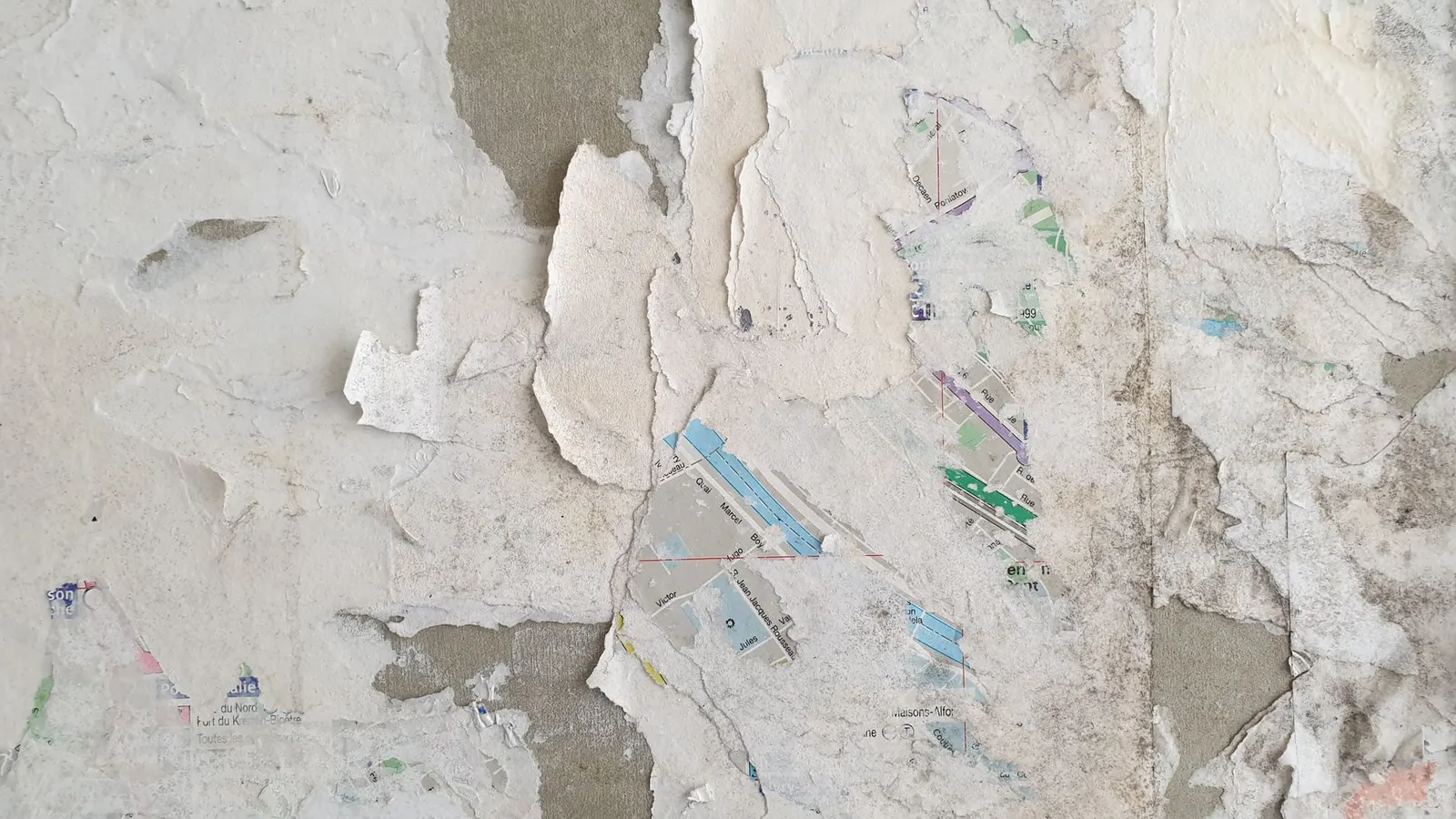 Close-up of peeling wallpaper layers on a textured wall